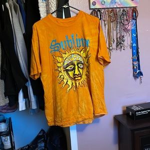 Orange T-shirt with sun, it says “sunshine”